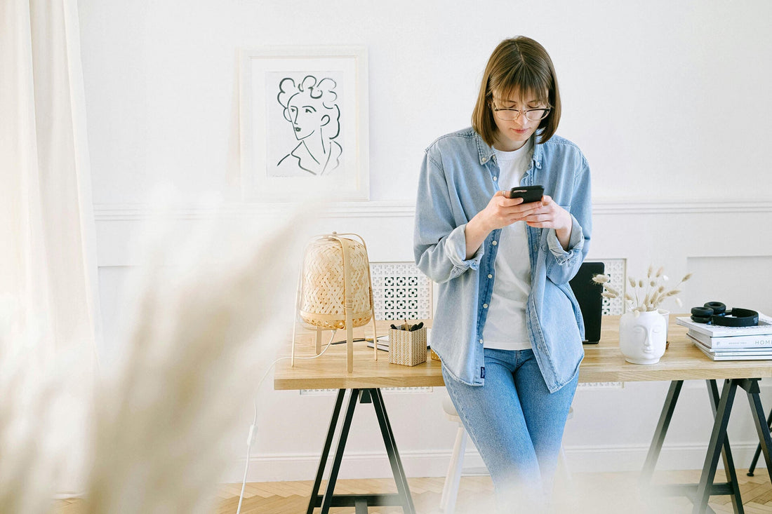 A woman is standing using her mobile phone while working